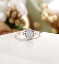 an opal and diamond ring sits on a table