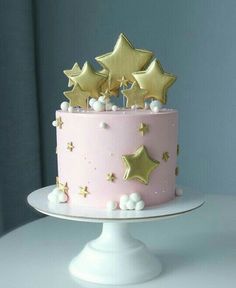 a pink and gold cake with stars on top