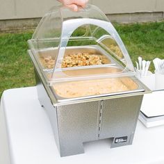 a person is holding a plastic container with food in it on top of a table