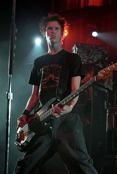 a young man playing a bass guitar on stage