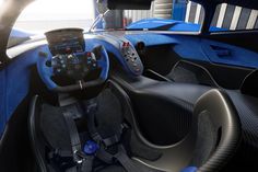 the interior of a blue sports car with steering wheel controls