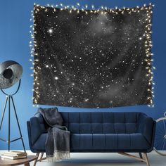 a living room with a blue couch and stars in the sky wall hanging above it