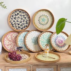 a table topped with plates and bowls filled with fruit next to a vase on top of a wooden table