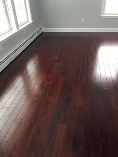 an empty room with hard wood flooring and white trim on the windowsills