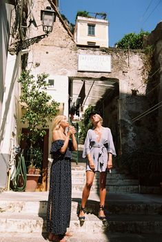 two women standing on steps talking to each other