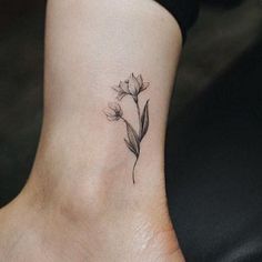 a small flower tattoo on the ankle