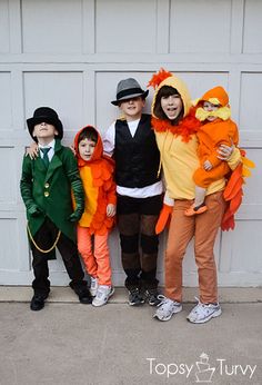 three children in costumes standing next to a garage door