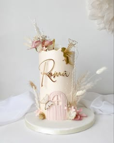 a white cake with pink and gold decorations on it's side, surrounded by feathers