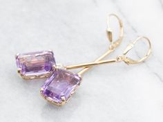 These elegant and luminous earrings feature yellow gold and amethyst set with a diamond accent, making it perfect for making a statement. Amethyst is known for its strength and protection properties, while the diamond accents provide the perfect touch of glam.Metal: 14K Yellow GoldGem: 2 Amethyst totaling 12.25 CaratsGem Measurements: 10.1 x 13.8 mm, Emerald CutAccents: 2 Diamonds totaling .10 Carats, SI in Clarity, G in ColorMeasurements: 10.1 x 54.3 mmMarks: "14KS" Stamped on the findings Amethyst Earrings Fine Jewelry For Formal Occasions, Amethyst Gemstone Earrings For Formal Occasions, Formal Amethyst Gemstone Earrings, Elegant Lavender Earrings With Gemstone Accents, Lavender Fine Jewelry Earrings For Formal Occasions, Formal Lavender Gemstone Earrings, Formal Lavender Fine Jewelry Earrings, Formal Lavender Amethyst Earrings, Lavender Drop Earrings For Formal Occasions