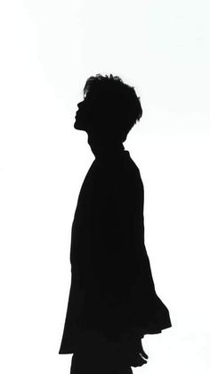 the silhouette of a person standing in front of a white background