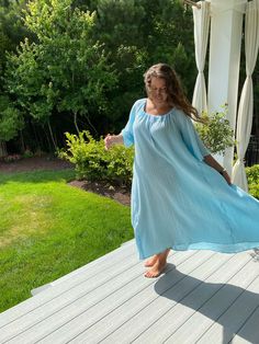 This nightgown is meant to be very, very loose. If you are looking for something more form fitting, it will not be to your liking. About 55 inches from shoulder to bottom front, back slightly longer. 80 inches round at hip level. The nightgown will have a cord to adjust the neck opening that may be white, pink, cream, green, blue... If multiple nightgowns are ordered, they will each have a different color cord.  Four yards of fabric are needed to craft this nightgown designed with only one purpose in mind: Your Comfort!  Machine wash in cold to warm water is recommended. Machine dry on low for 20 minutes then finish by line drying. Or simply line dry. The cotton 2-layer gauze nightgown is light and airy. In a beautiful baby blue color and white cord. So pretty! Like sleeping in a cloud... Blue Long Sleeve Sleepwear For Vacation, Summer Long Sleeve Nightgown For Lounging, Breezy Flowy Loungewear Dress, Blue Summer Sleep Dress, Oversized Summer Dresses For Loungewear, Oversized Summer Loungewear Dress, Spring Blue Nightgown For Lounging, Blue Nightgown For Spring Lounging, Blue Spring Nightgown For Lounging