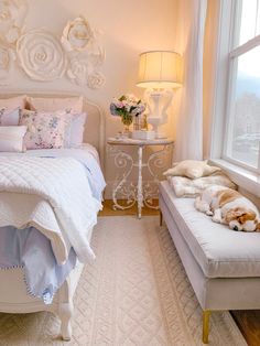 a white bed sitting next to a window with flowers on the headboard and foot board