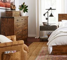 a bed sitting in a bedroom next to a wooden dresser and chair on top of a hard wood floor