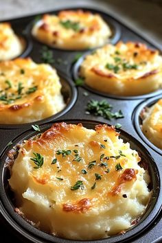 baked potatoes in a muffin tin with parmesan cheese and herbs on top