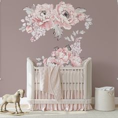 a baby crib with pink flowers on the wall