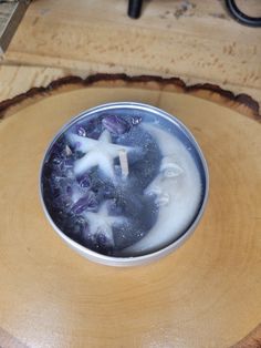 a bowl filled with liquid sitting on top of a wooden table