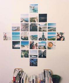 a book shelf filled with books next to a white wall covered in pictures and photos