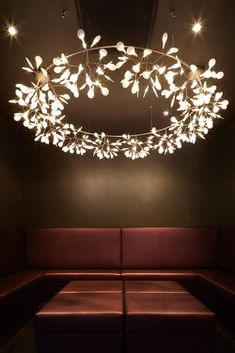 a couch with lights hanging from it's ceiling in a dimly lit room,