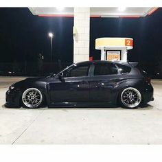 a black car parked in front of a gas station