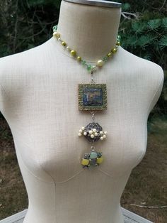 This is an assemblage of up-cycled vintage pins and pendants inspired by my Mom's jewelry box filled with pins, earrings, and strings of pearls from the '40s and '50s. It  features a beautiful green, yellow, cream, chain of faux pearls and crystal beads. Then a long pendant of two vintage pins and one pendant. Each pin-pendant has a lobster clasp so you can choose to wear one, two, or all three with the pearl chain necklace. The necklace is adjustable 16 to 18 inches. The pin-pendants are 6 inches long with all three attached as shown. There is a pair of matching earrings that are listed separately on my shop shown in a few of the pictures that are not a part of this sale. Vintage Upcycled Jewelry As Gift, Upcycling Jewelry, Artsy Clothes, Vintage Assemblage Necklace, Old Jewelry Crafts, Pins Earrings, Assemblage Earrings, Vintage Assemblage Jewelry, Shabby Chic Jewelry