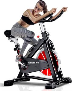 a woman is riding an exercise bike on a white background with red and black stripes