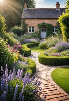 a garden with lots of green grass and purple flowers in front of a brick house