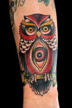 an owl tattoo on the arm