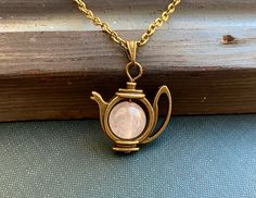 This is a fabulously bohemian Alice in Wonderland inspired necklace with a pink rose quartz gemstone pearl and a kitsch teapot pendant. Handcrafted in Finland by Selma Dreams. The necklace is made of antiqued bronze, all the materials are lead and nickel safe. There are three length options for the chain, please choose your favourite from the drop down menu. Custom length is also an option, simply leave a note with your order. Rose quartz is light pink colour crystal and is said to be the crystal of love, peace and inner balance. The necklace will be sent in a lovely little gift box ready for gifting. There are matching earrings available from my shop. If you have any questions or would like the necklace in different colour, do contact me. Spiritual Pink Charm Necklace As Gift, Pink Spiritual Charm Necklace For Gift, Spiritual Pink Charm Necklace For Gift, Rose Gold Necklace With Vintage Charm For Gift, Charming Pink Necklace For Gift, Handmade Pink Charm Necklaces For Mother's Day, Mother's Day Pink Handmade Charm Necklace, Whimsical Jewelry With Vintage Charm As A Gift, Vintage Pink Gemstone Necklace