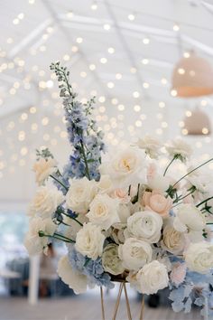 a vase filled with lots of white and blue flowers