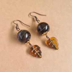 "Details * Handmade item * Dispatches from a small business in Singapore * Metal: Copper Alloy * Gemstone: Banded Agate * Location: Earrings * Earring Type : Hook * Style: Rustic Description A fan of Autumn? Reflect the season's colours with this pair of banded agate beads earrings topped with gold coloured stainless steel flower bead caps with cognac leaf czech glass beads dangles. The copper earring hooks are light weight and compliments the mix of browns and patterns of the agate beads.  As g Brown Adjustable Earrings With Natural Stones, Brown Czech Glass Jewelry Gift, Handmade Tortoiseshell Jewelry Gift, Handmade Brown Glass Jewelry, Handmade Amber Agate Earrings, Nickel-free Brown Czech Glass Earrings, Nickel-free Brown Earrings With Czech Glass, Nickel-free Brown Czech Glass Jewelry, Nickel Free Brown Earrings With Czech Glass