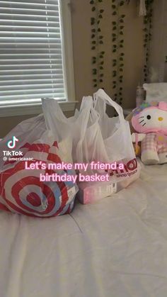 a hello kitty stuffed animal sitting on top of a bed next to plastic bags and other items