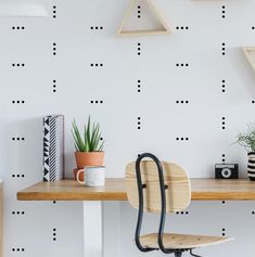 a desk with a chair, potted plant and other items on top of it