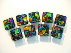 six square glass beads with colorful designs on them