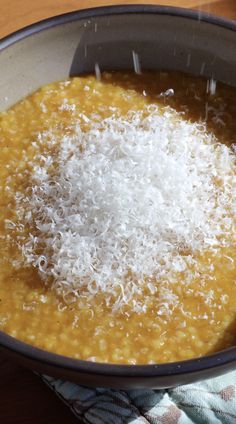 a bowl filled with soup on top of a wooden table next to a spoon and napkin