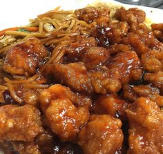 a white plate topped with meat and noodles