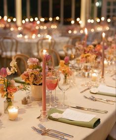 the table is set with candles, flowers and menus for an elegant wedding reception