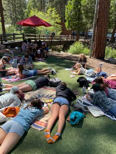 many people are laying on the grass and relaxing