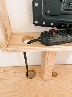 a remote control sitting on top of a wooden shelf