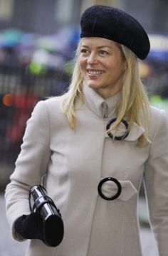 a woman in a white coat and black hat