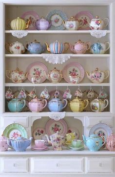 a china cabinet filled with lots of tea cups and saucers