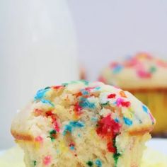 a cupcake with sprinkles is on a plate next to a muffin