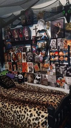 a bedroom with pictures on the wall and a leopard print bed spread in front of it