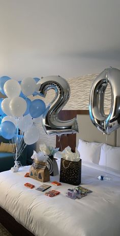 balloons and gifts on a bed with the number twenty two in front of them,