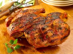 two pieces of meat sitting on top of a wooden cutting board