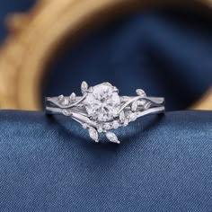 a diamond ring sitting on top of a blue cushion