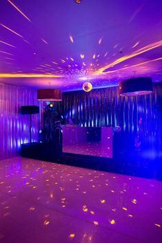 an empty dance floor with purple lights in the background