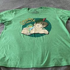 a green t - shirt with an image of a cartoon character on it