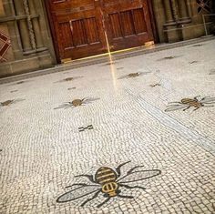 two bees on the ground in front of a building with wooden doors and brick flooring