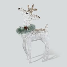 a white and silver reindeer ornament with pine cones