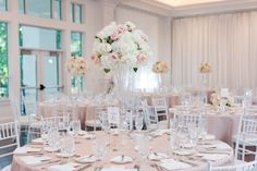 the tables are set with white and pink flowers